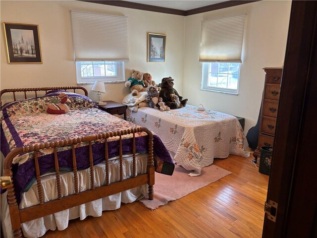 bedroom with crown molding and light hardwood / wood-style floors