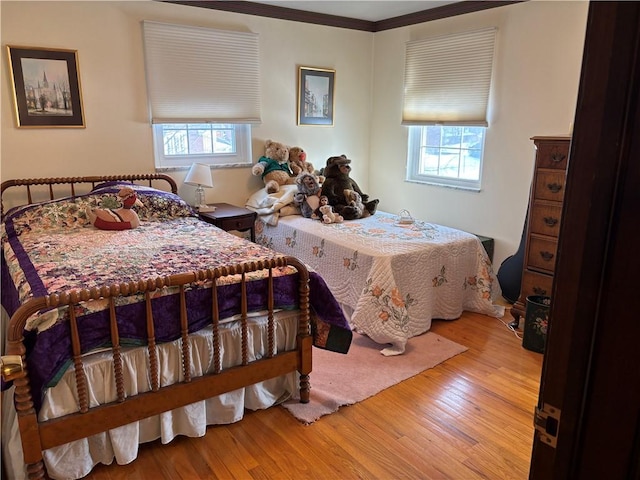 bedroom featuring wood finished floors and crown molding