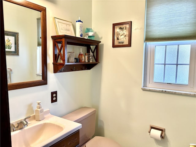 half bath featuring vanity and toilet