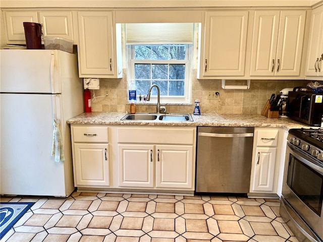 kitchen featuring white cabinets, stainless steel appliances, a sink, and light countertops