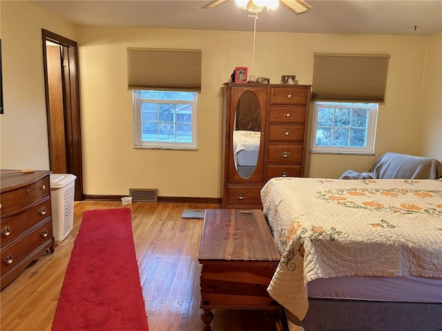 bedroom featuring multiple windows, light hardwood / wood-style floors, and ceiling fan