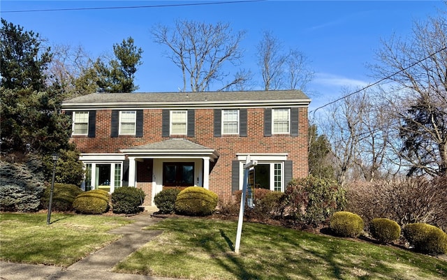 colonial house with brick siding and a front yard