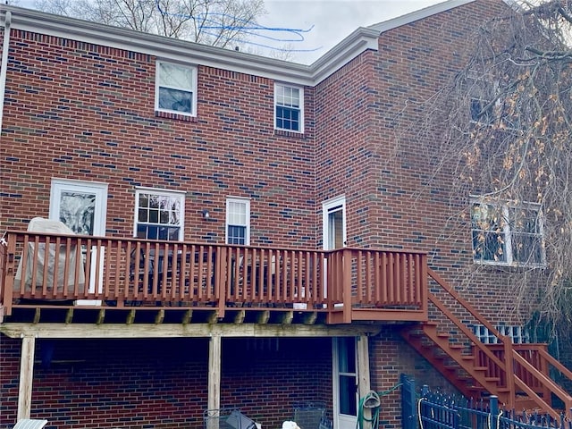 rear view of house featuring stairway and brick siding