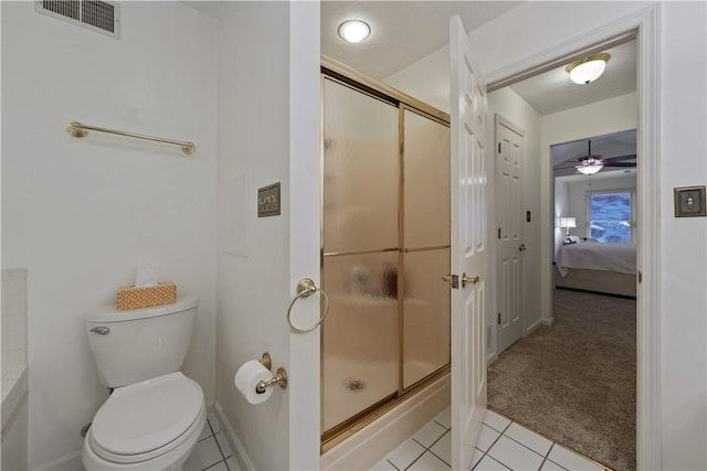 bathroom featuring toilet, an enclosed shower, and tile patterned flooring