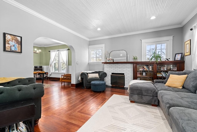 living room with hardwood / wood-style flooring, crown molding, and a fireplace