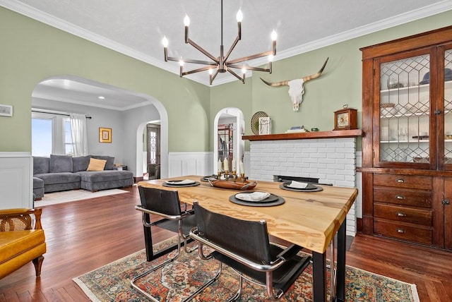 dining area featuring crown molding, an inviting chandelier, and dark hardwood / wood-style flooring