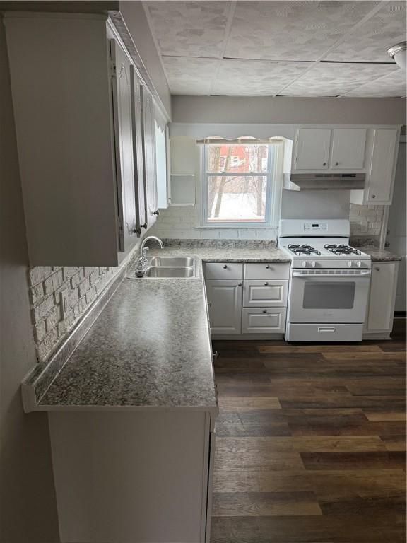 kitchen with white gas range, dark hardwood / wood-style flooring, sink, and white cabinets