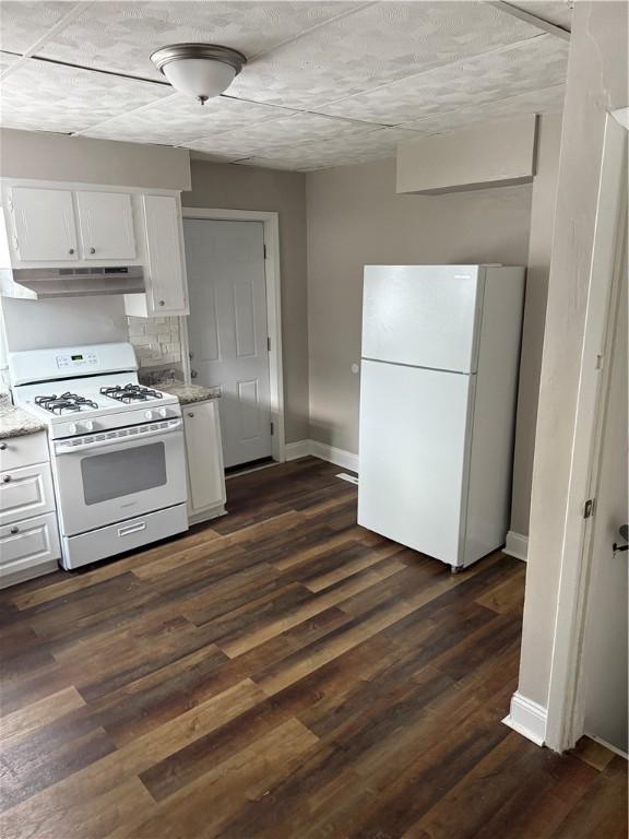 kitchen featuring white cabinetry, light stone counters, white appliances, and dark hardwood / wood-style flooring