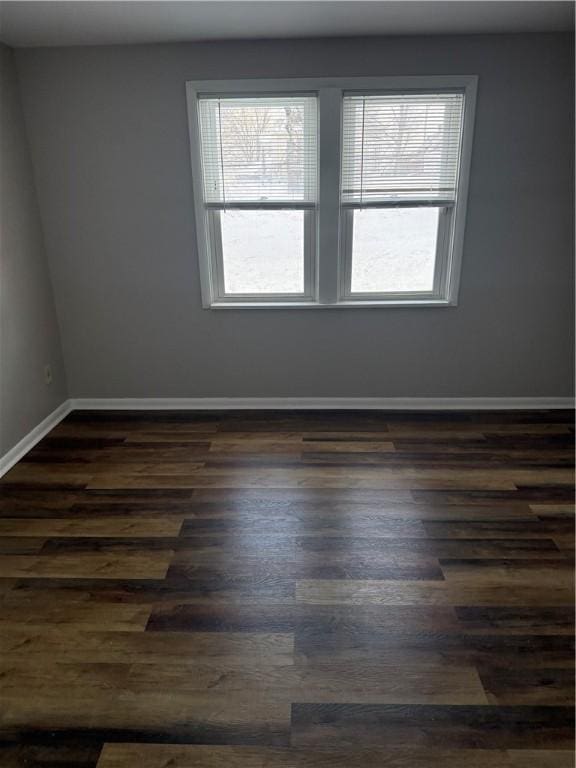 unfurnished room with dark wood-type flooring