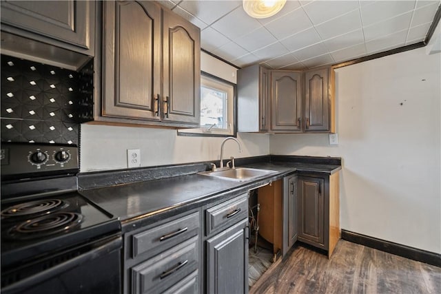 kitchen featuring dark hardwood / wood-style flooring, black electric range oven, dark brown cabinets, and sink