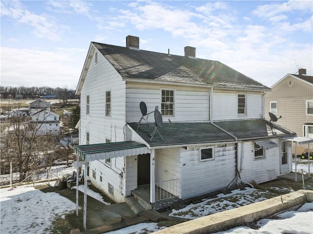 view of snow covered back of property