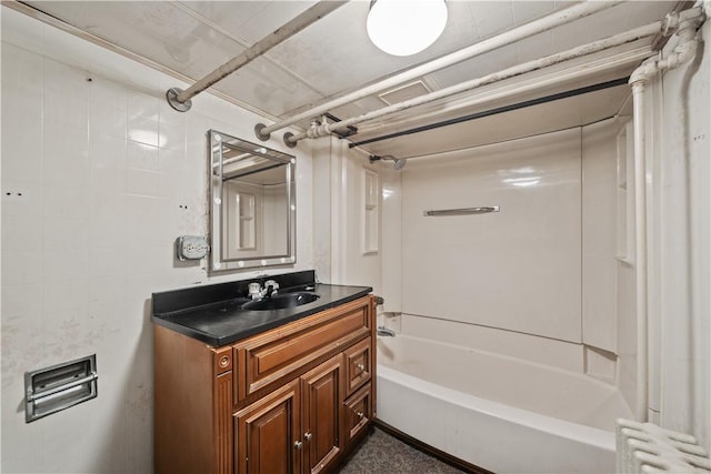 bathroom with vanity, radiator heating unit, and  shower combination