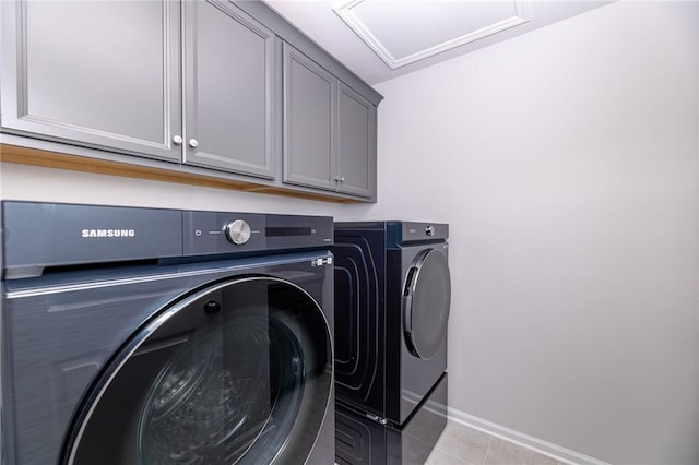 clothes washing area with cabinets, light tile patterned floors, and independent washer and dryer