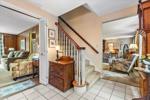 stairs featuring wood walls and carpet