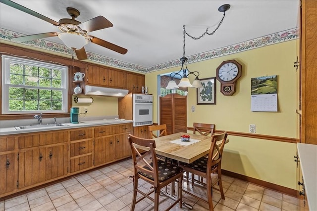 tiled dining room with sink and ceiling fan