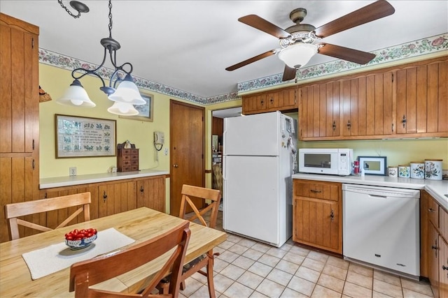 kitchen with light tile patterned floors, ceiling fan with notable chandelier, white appliances, and decorative light fixtures