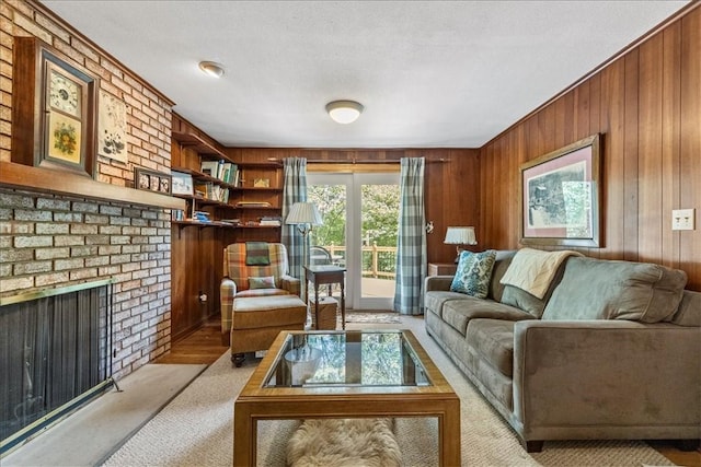 carpeted living room with a fireplace, a textured ceiling, and wood walls