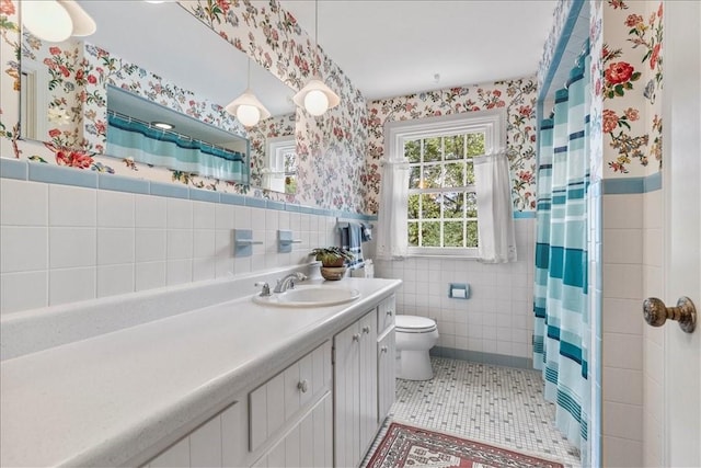 bathroom featuring tile patterned flooring, tile walls, a shower with shower curtain, vanity, and toilet