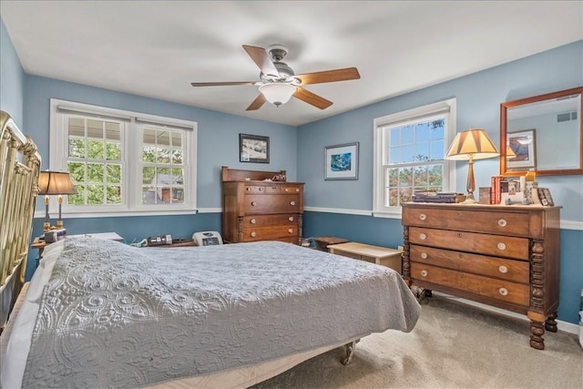 carpeted bedroom with multiple windows and ceiling fan