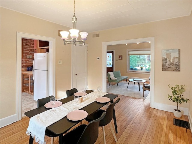 dining room with a chandelier and light wood-type flooring