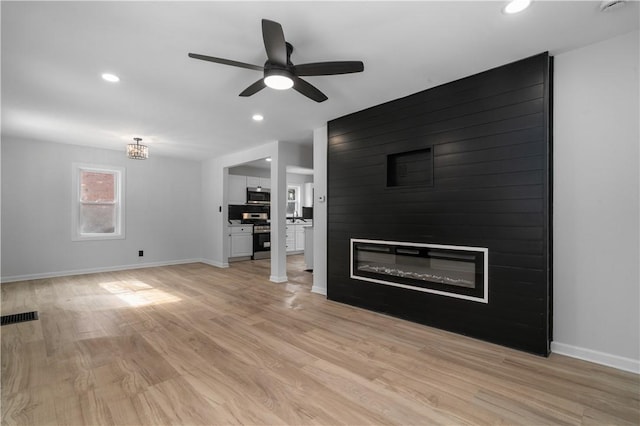 unfurnished living room with a fireplace, light hardwood / wood-style floors, and ceiling fan