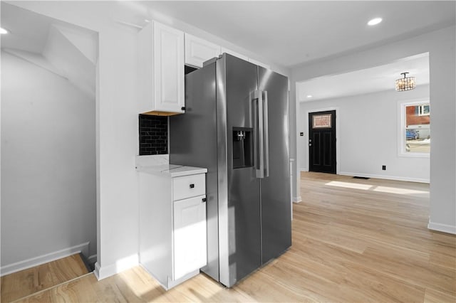 kitchen with tasteful backsplash, high end fridge, light hardwood / wood-style flooring, and white cabinets