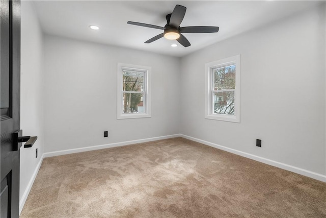 carpeted empty room with a wealth of natural light and ceiling fan