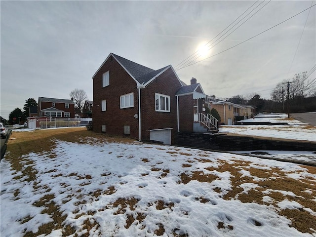 snow covered property with a garage