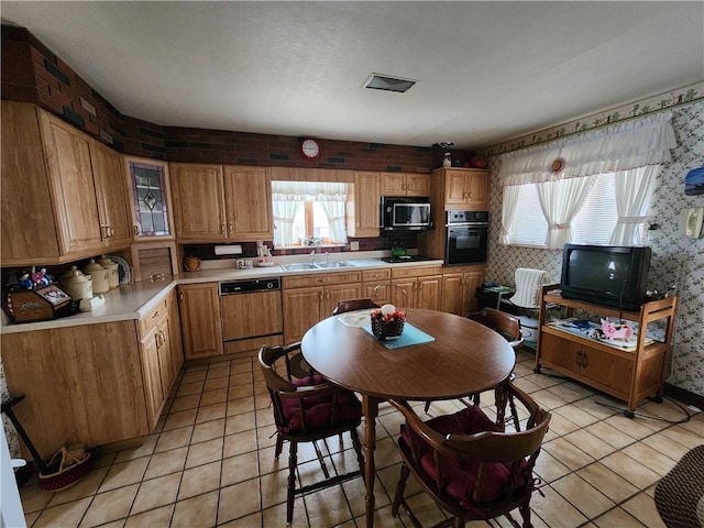 kitchen with a healthy amount of sunlight, sink, light tile patterned floors, and black appliances