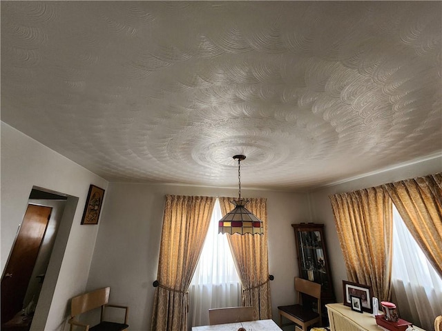 unfurnished dining area featuring a textured ceiling