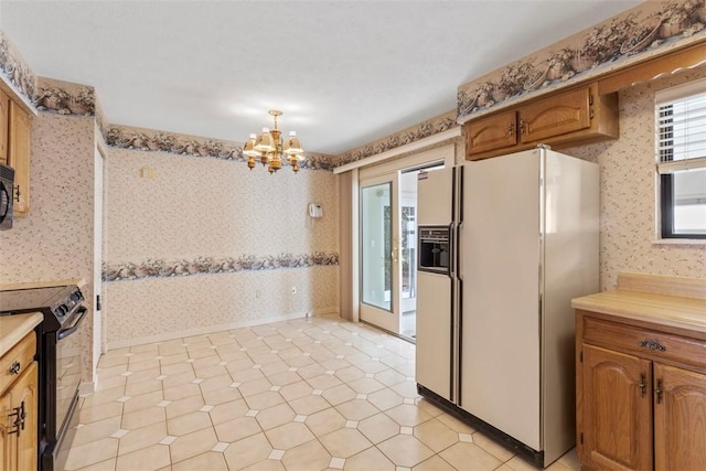 kitchen featuring hanging light fixtures, a notable chandelier, and black appliances