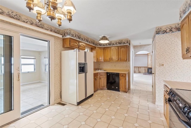 kitchen with sink, dishwasher, electric range oven, white fridge with ice dispenser, and a chandelier