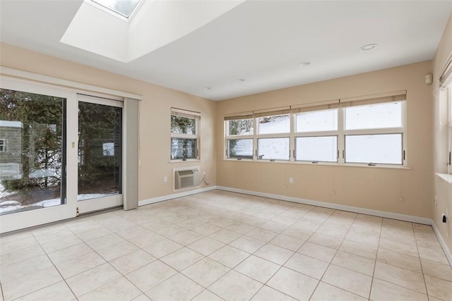 tiled empty room featuring a wall unit AC and a skylight