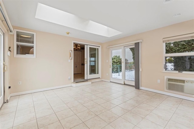 tiled spare room with a wall mounted air conditioner and a skylight