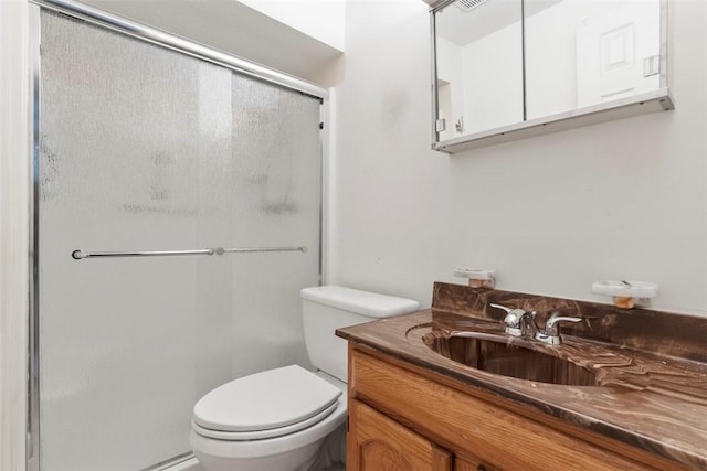 bathroom featuring vanity, an enclosed shower, and toilet