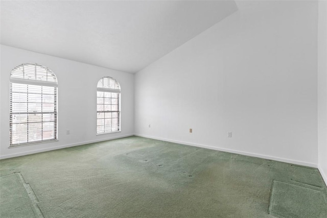 carpeted empty room featuring lofted ceiling