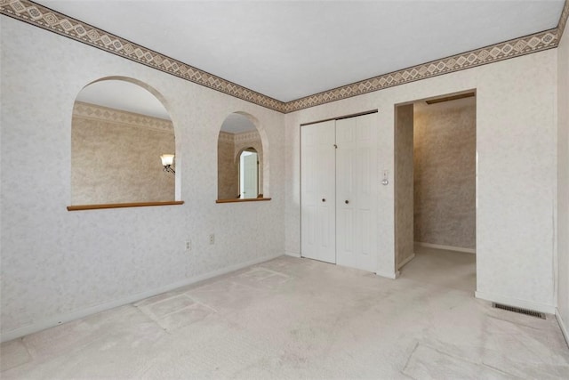 unfurnished bedroom featuring a closet and light carpet