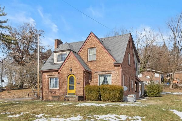 tudor-style house featuring a front lawn