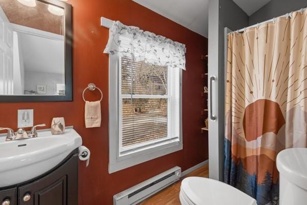 bathroom with baseboard heating, vanity, toilet, and a shower with shower curtain