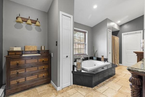 bathroom featuring tiled tub, a baseboard radiator, and lofted ceiling