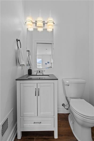 bathroom featuring vanity, wood-type flooring, and toilet