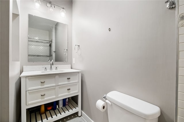 bathroom with vanity, toilet, and tiled shower