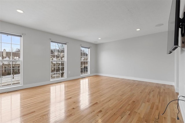 spare room with plenty of natural light and light wood-type flooring