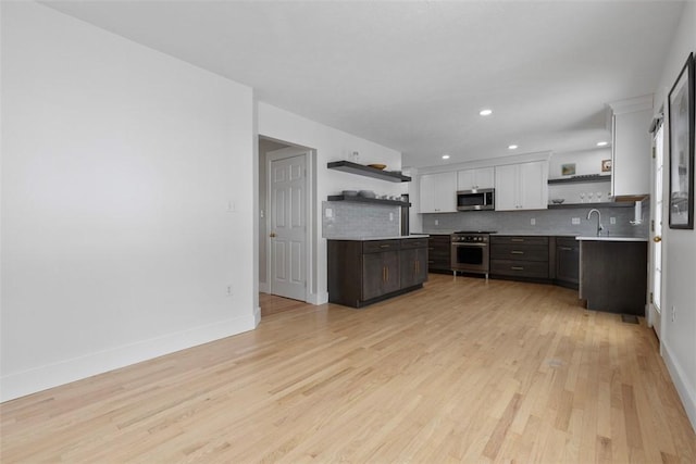 kitchen with dark brown cabinetry, sink, tasteful backsplash, appliances with stainless steel finishes, and white cabinets