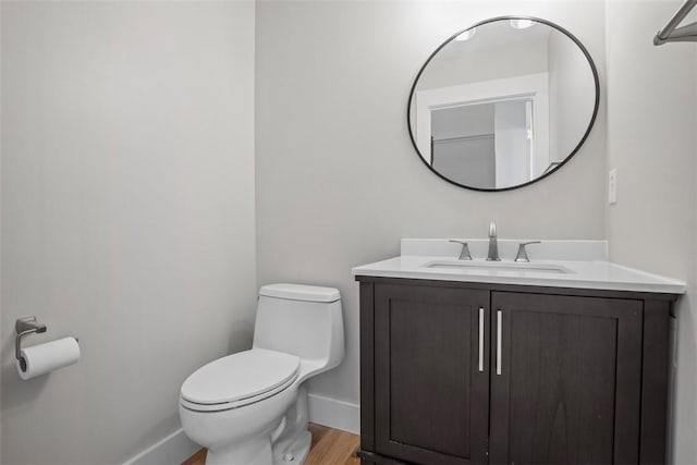 bathroom with vanity, toilet, and hardwood / wood-style floors