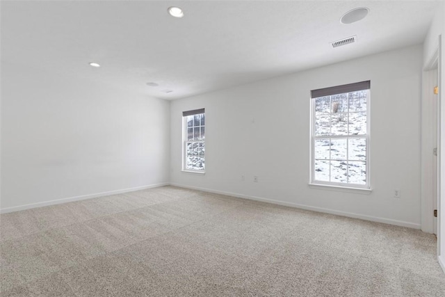 carpeted spare room featuring a healthy amount of sunlight