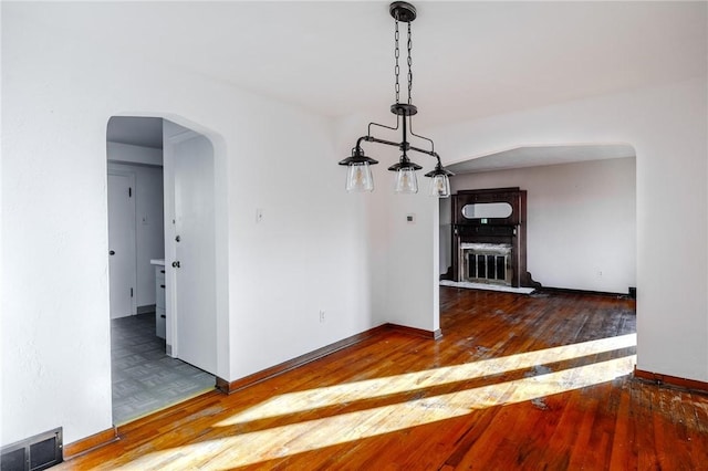 unfurnished dining area with dark wood-type flooring