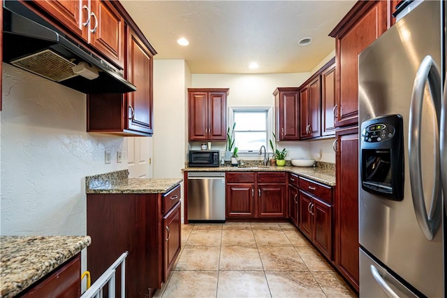 kitchen featuring light stone counters, stainless steel appliances, sink, and light tile patterned floors