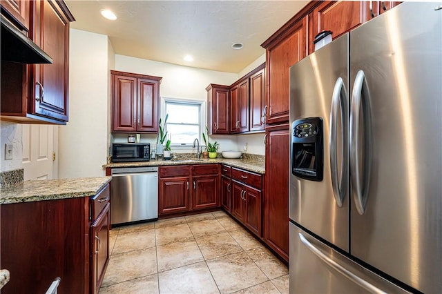 kitchen with stainless steel appliances, sink, light tile patterned floors, and light stone counters