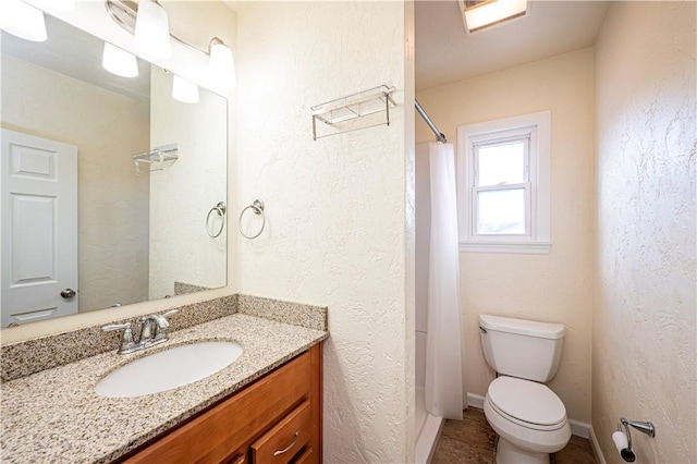 bathroom with vanity, curtained shower, and toilet